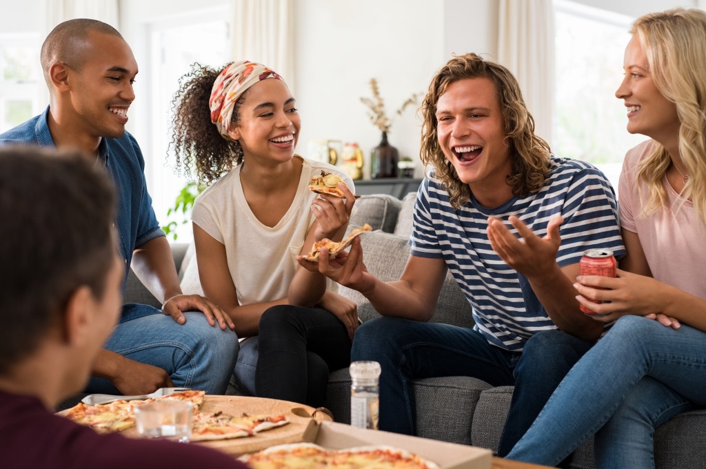 Friends get together while eating pizza