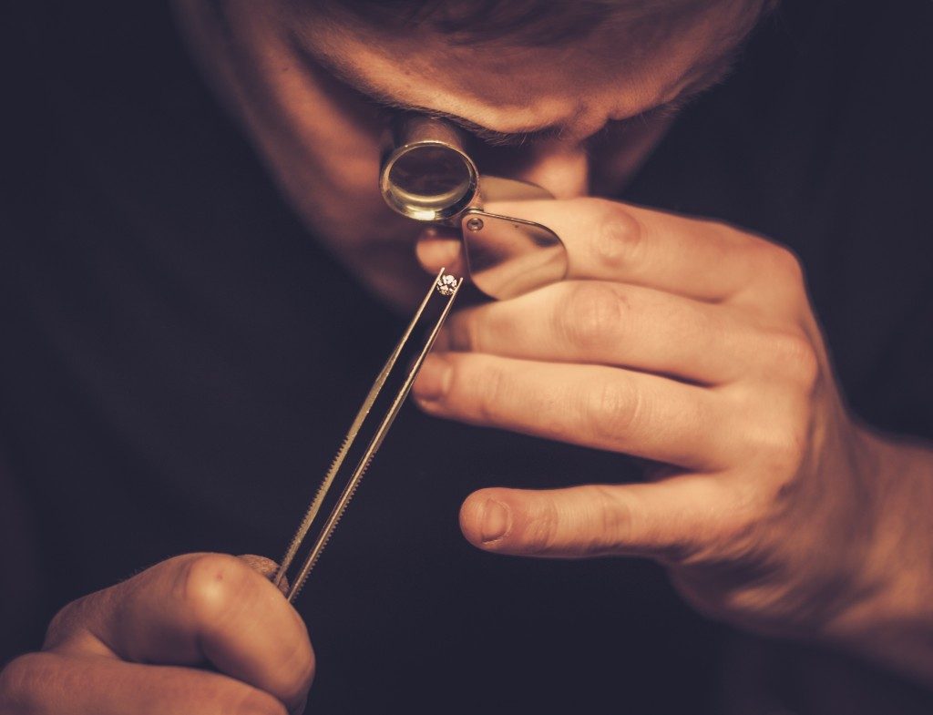 man inspecting a diamond closely