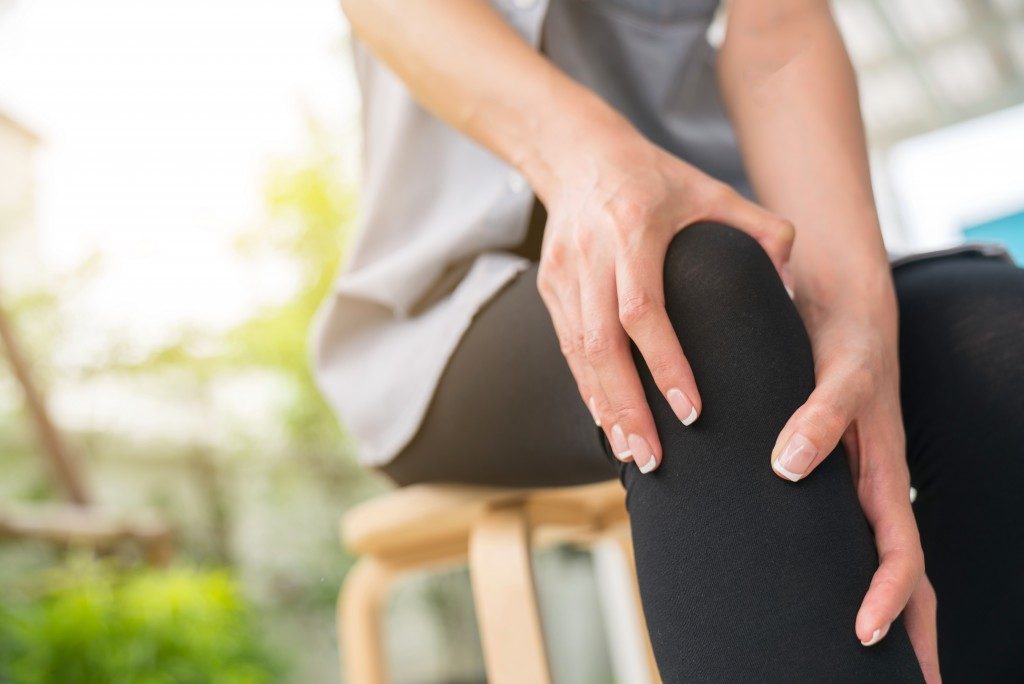 a person suffering from rheumatoid arthritis holding his knee