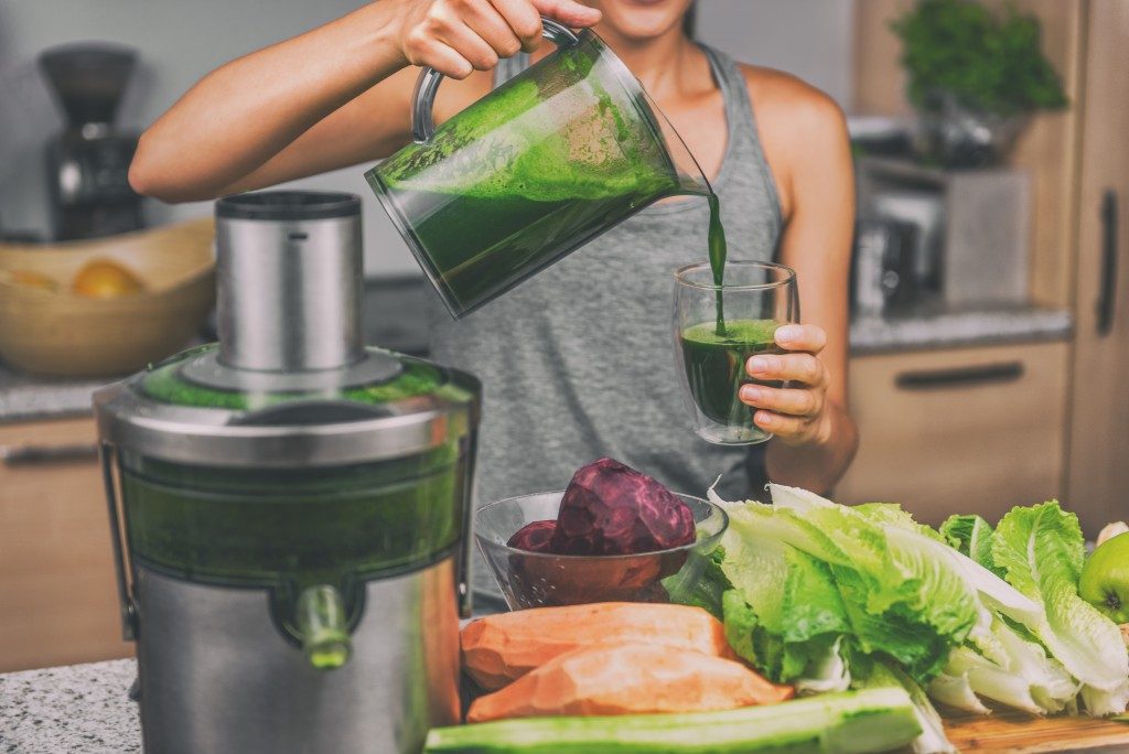 woman juicing vegetables