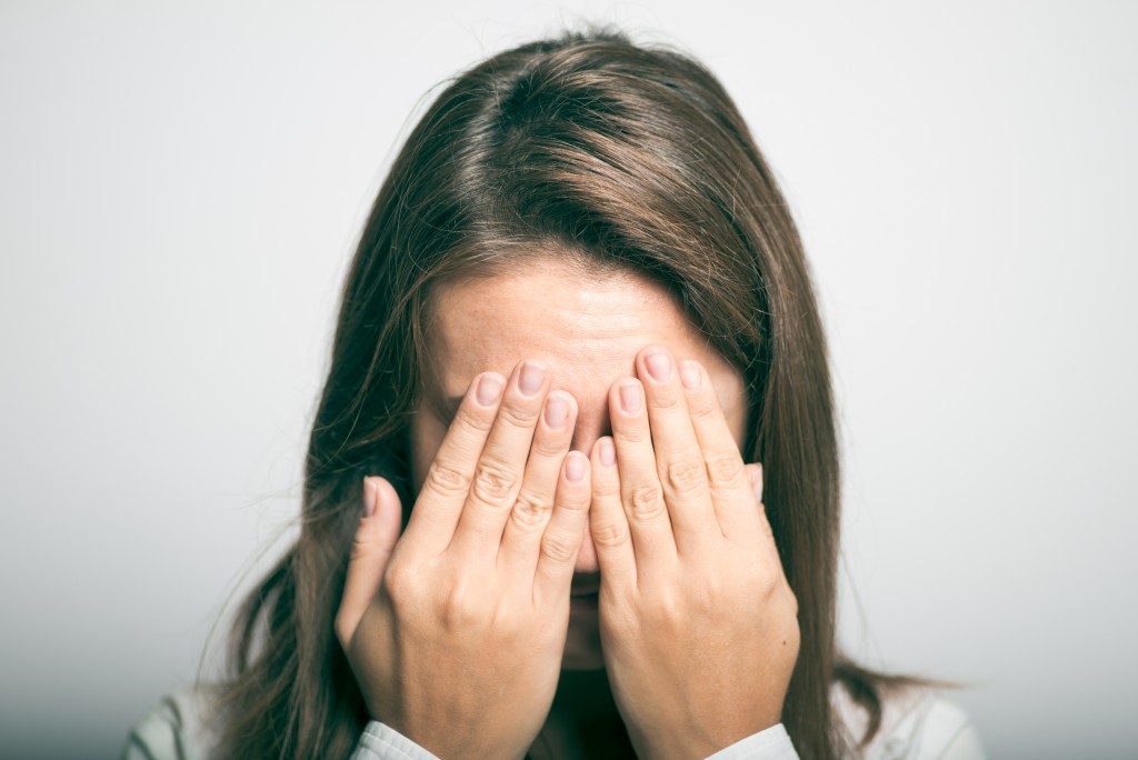 frustrated woman covering her face