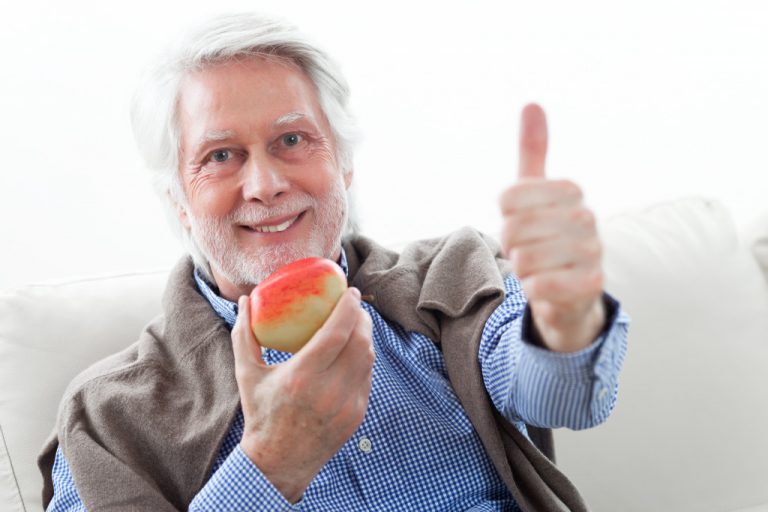 elderly person holding a fruit