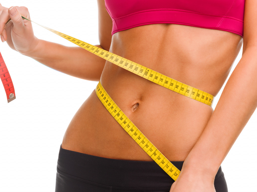 fitness concept shown through measuring tape around toned belly