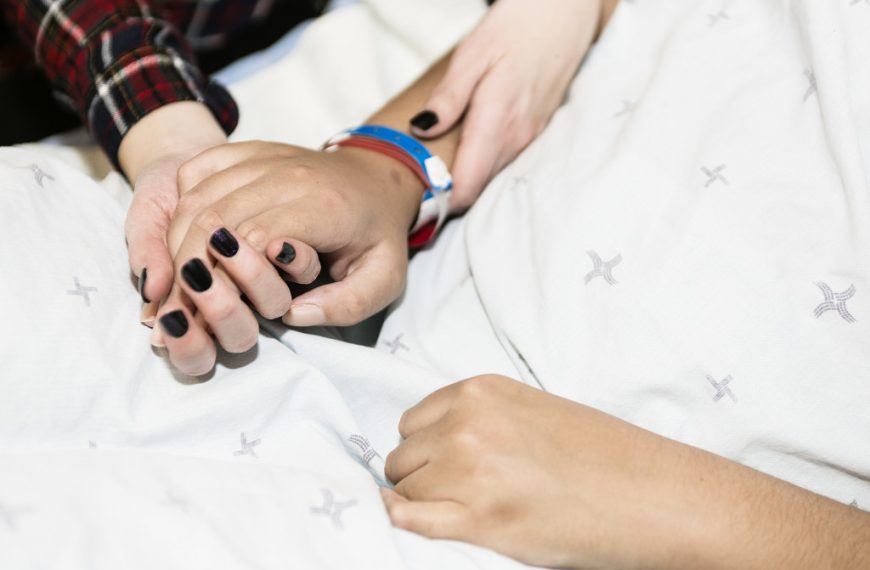 a woman holding a sick person's hand